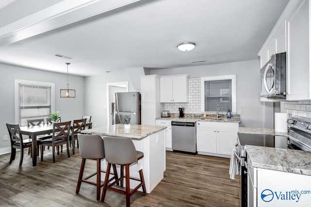 kitchen with decorative backsplash, visible vents, a sink, and appliances with stainless steel finishes