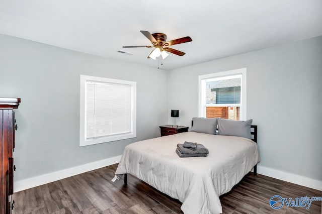 bedroom featuring baseboards, wood finished floors, visible vents, and a ceiling fan