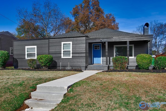 view of front facade featuring a chimney and a front yard