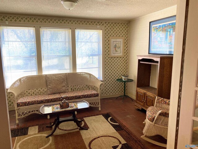 living area with baseboards, wallpapered walls, crown molding, and a textured ceiling