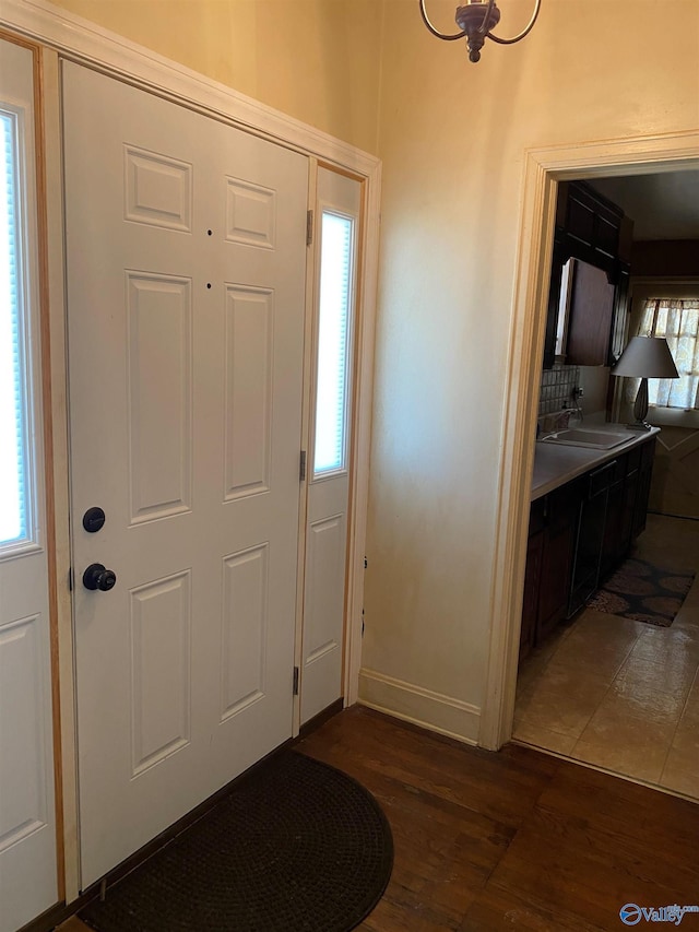 entryway with dark wood-type flooring and baseboards