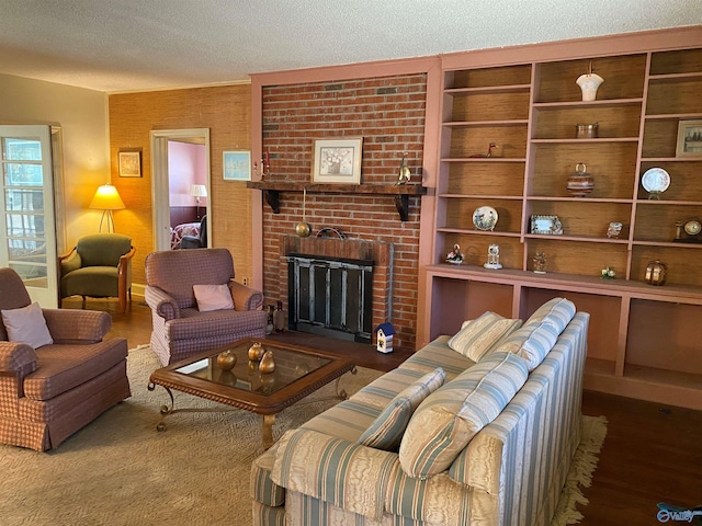 living area featuring a textured ceiling, a fireplace, and wood finished floors