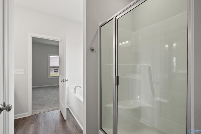 bathroom with wood-type flooring and separate shower and tub