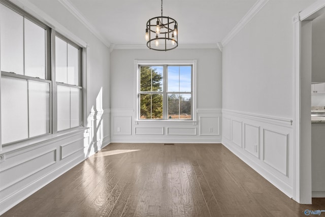 unfurnished dining area featuring an inviting chandelier, dark hardwood / wood-style flooring, and ornamental molding