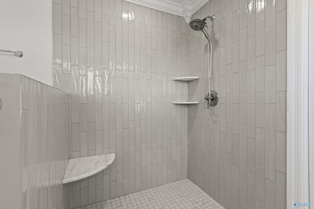 bathroom featuring crown molding and a tile shower