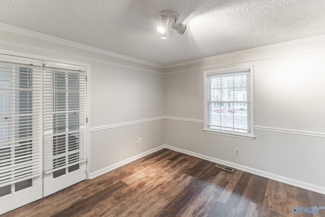 unfurnished room with visible vents, a textured ceiling, wood finished floors, and crown molding