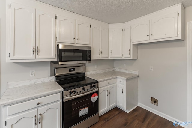 kitchen with dark hardwood / wood-style floors, white cabinetry, a textured ceiling, and appliances with stainless steel finishes