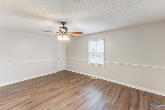 empty room with a textured ceiling, ceiling fan, and dark hardwood / wood-style floors