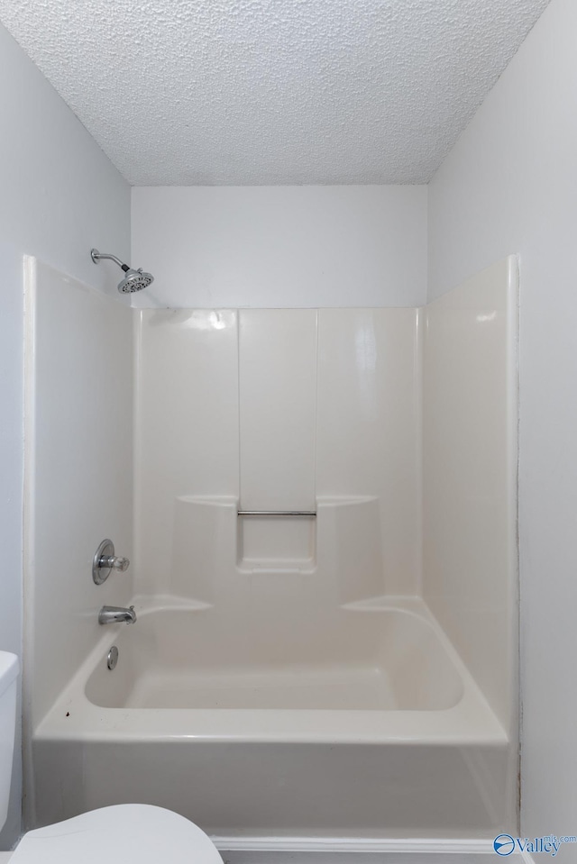 bathroom featuring a textured ceiling, toilet, and shower / bathtub combination