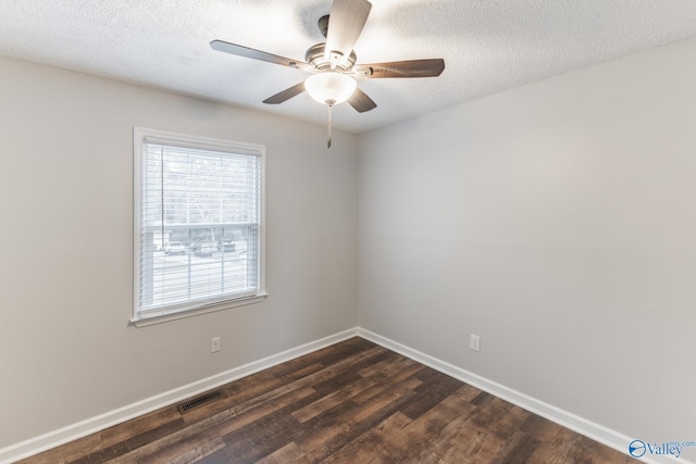 spare room with visible vents, a textured ceiling, dark wood finished floors, baseboards, and ceiling fan