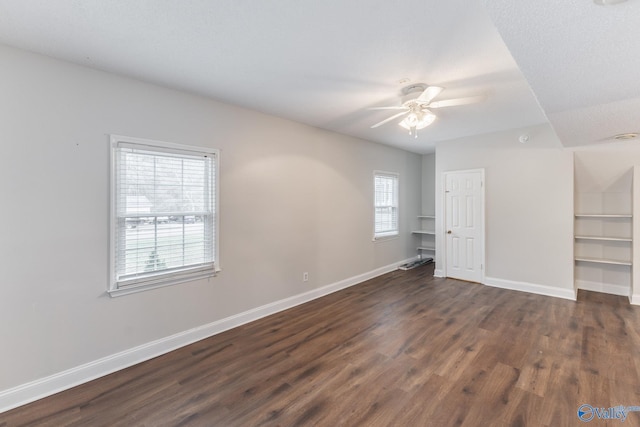 unfurnished bedroom featuring baseboards, dark wood-style floors, and a ceiling fan