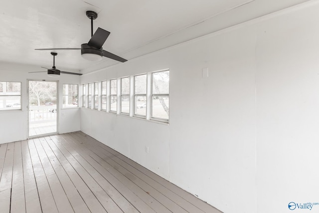 unfurnished sunroom featuring ceiling fan