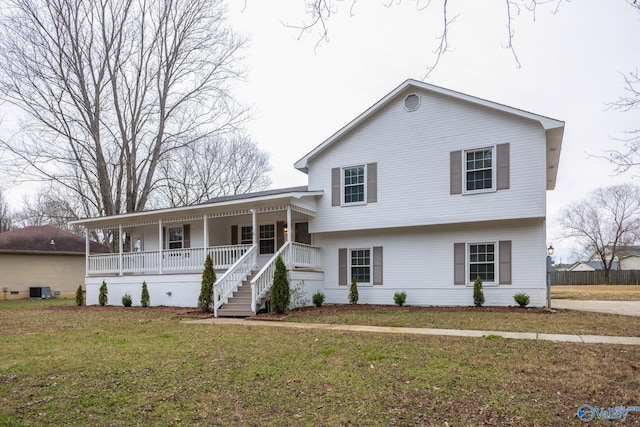 split level home with central AC unit, a porch, and a front yard