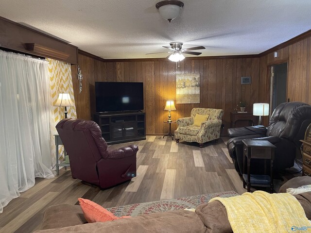 living room with crown molding, ceiling fan, hardwood / wood-style flooring, and a textured ceiling