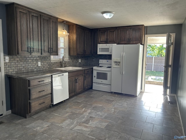 kitchen featuring a sink, backsplash, white appliances, and a textured ceiling
