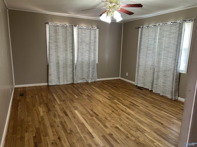 empty room featuring ornamental molding, ceiling fan, and wood finished floors