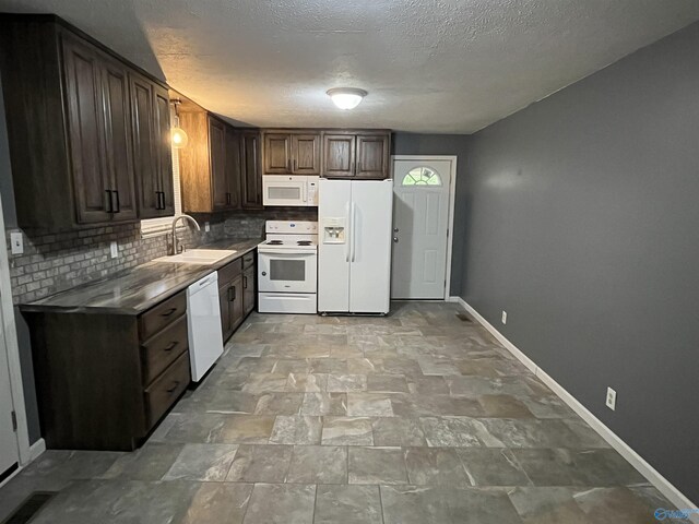 kitchen featuring visible vents, decorative backsplash, white appliances, a textured ceiling, and a sink