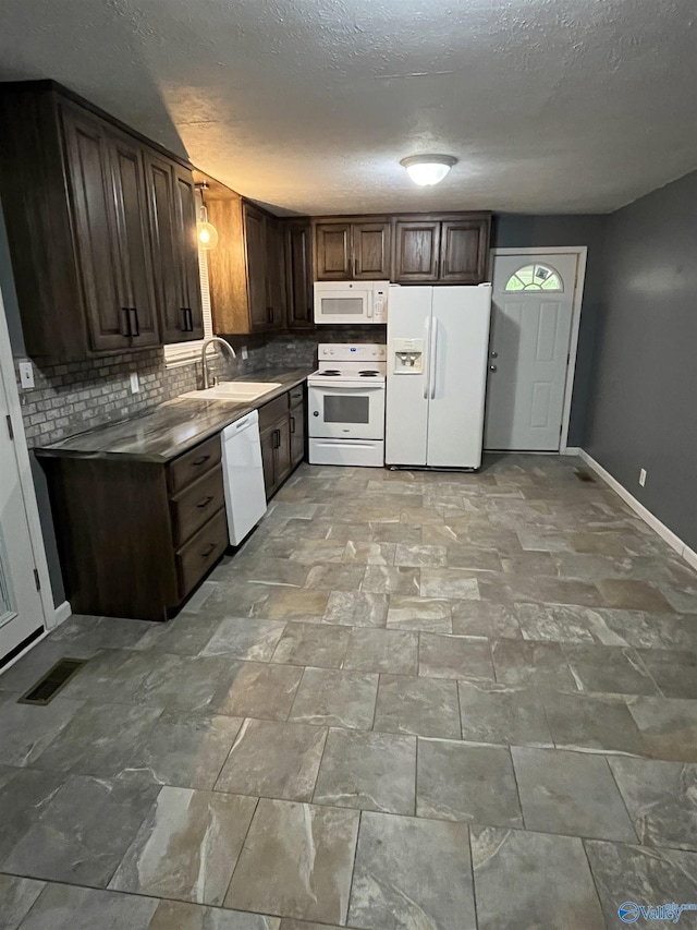 kitchen featuring a sink, white appliances, baseboards, decorative backsplash, and visible vents