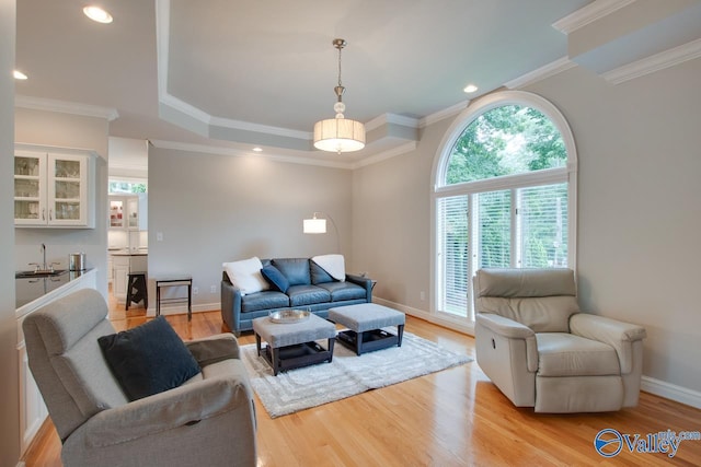 living area featuring recessed lighting, light wood-style flooring, baseboards, and ornamental molding