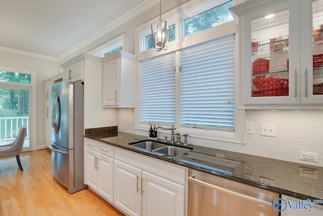 kitchen featuring ornamental molding, appliances with stainless steel finishes, a sink, and white cabinetry