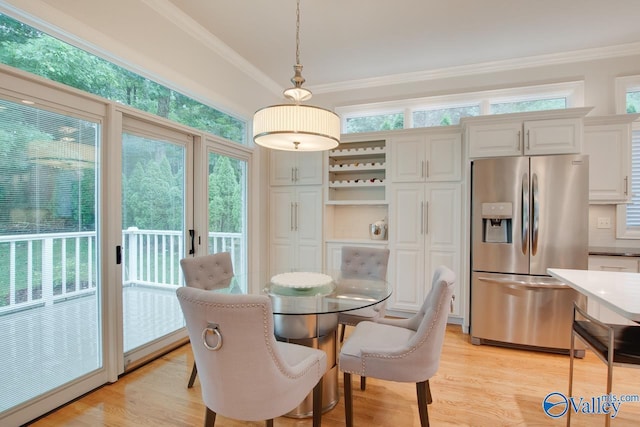 dining room with ornamental molding and light wood-style flooring