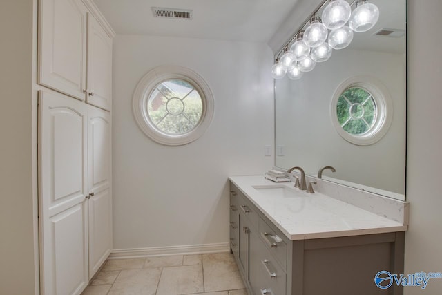 bathroom featuring baseboards, visible vents, and vanity