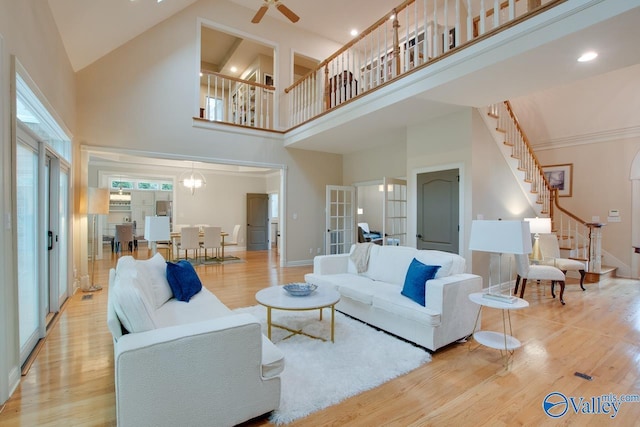 living room featuring baseboards, stairway, wood finished floors, and french doors