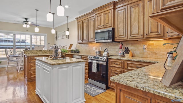 kitchen featuring stainless steel appliances, light stone counters, brown cabinetry, and crown molding