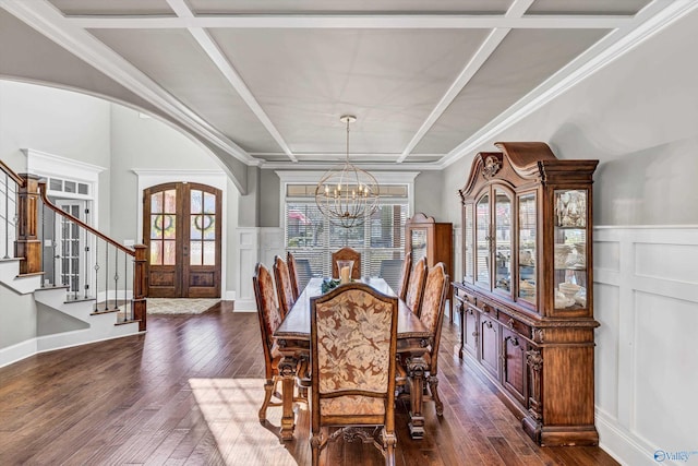 dining room featuring arched walkways, french doors, coffered ceiling, and stairs