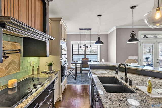 kitchen featuring black electric stovetop, a sink, ornamental molding, light stone countertops, and dark wood-style floors