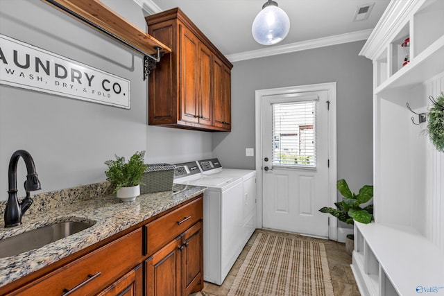 laundry area with cabinet space, visible vents, crown molding, washing machine and dryer, and a sink