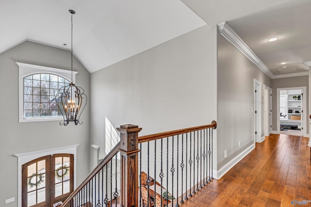 hall with baseboards, lofted ceiling, hardwood / wood-style flooring, french doors, and a chandelier