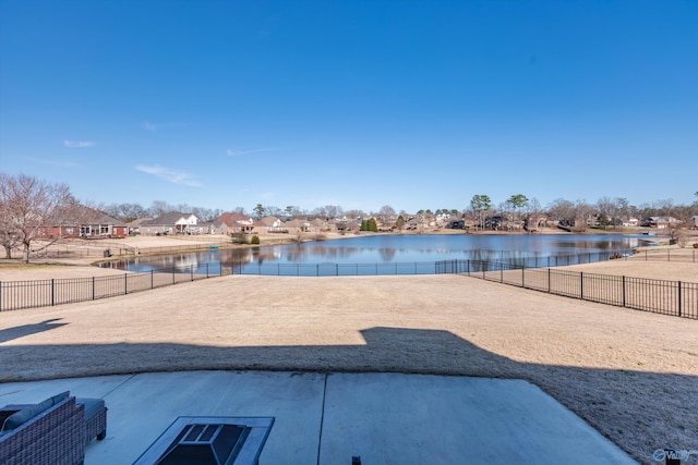 view of pool featuring a water view and a fenced backyard