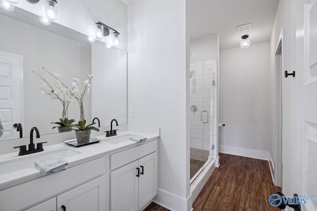 bathroom featuring vanity, a shower with shower door, and wood-type flooring