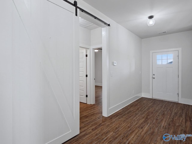 foyer featuring a barn door and dark hardwood / wood-style flooring