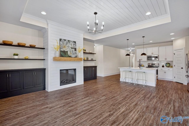 unfurnished living room with a large fireplace, dark wood-type flooring, wooden ceiling, and a raised ceiling