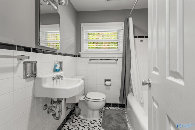 full bathroom featuring shower / tub combo, tasteful backsplash, tile walls, toilet, and tile patterned floors