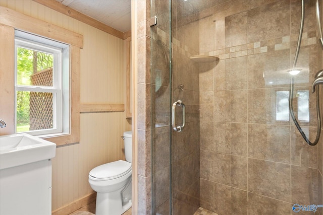 bathroom featuring wood walls, vanity, an enclosed shower, and toilet