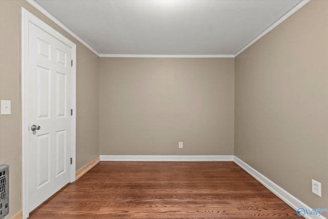 empty room featuring wood-type flooring and crown molding