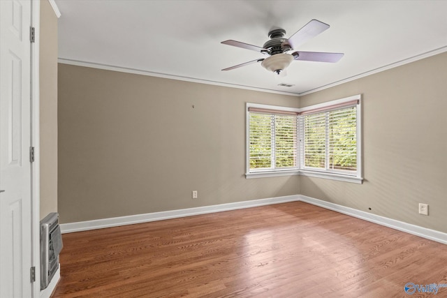 empty room with ceiling fan, crown molding, and hardwood / wood-style flooring