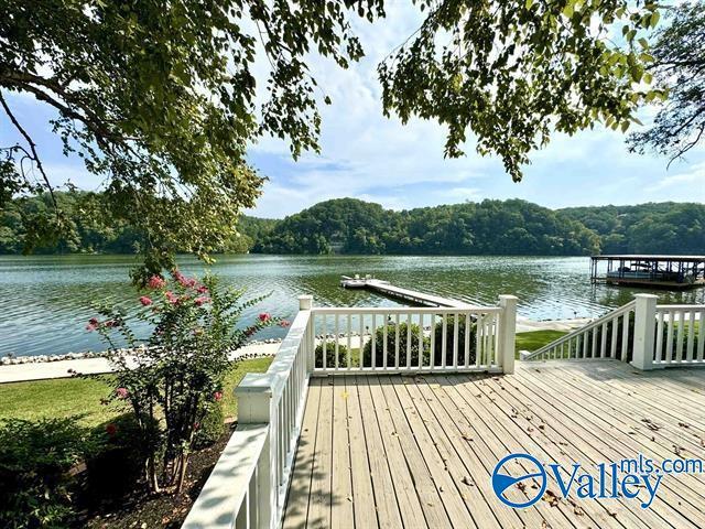 view of dock featuring a water view and a forest view