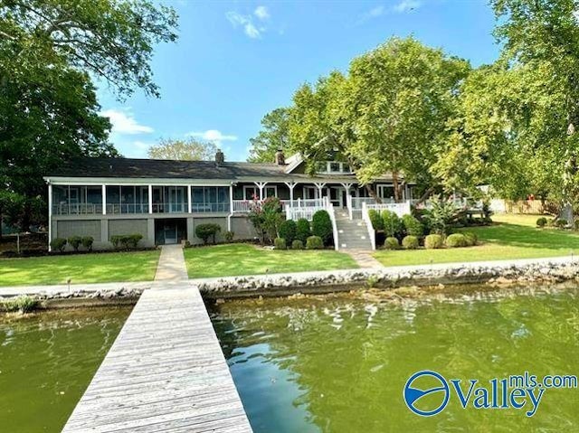 view of dock with a water view and a yard