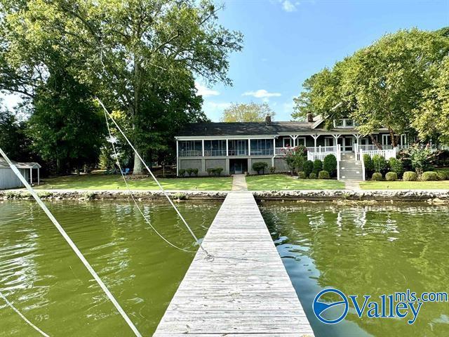 dock area featuring a water view and a lawn