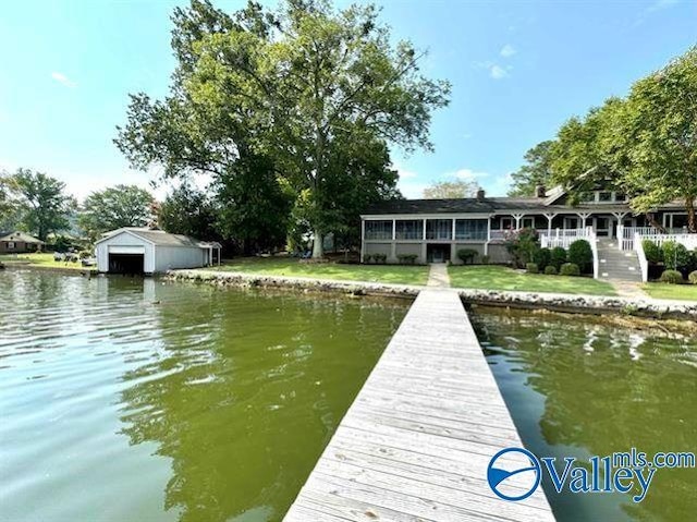 view of dock with a water view and a lawn