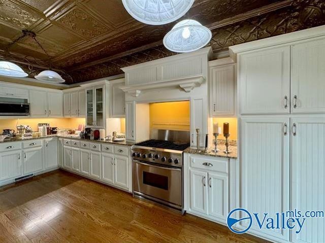 kitchen featuring an ornate ceiling, dark wood-style flooring, white cabinetry, and appliances with stainless steel finishes