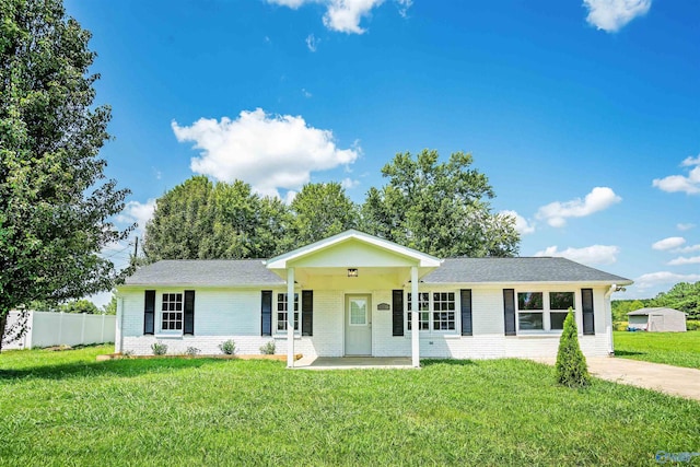 ranch-style house featuring covered porch and a front yard