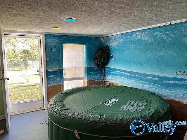 bedroom with concrete flooring and a textured ceiling