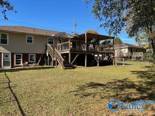 rear view of house with a lawn and a deck