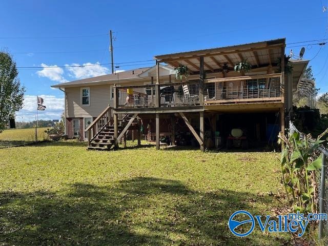 back of property with a yard and a wooden deck