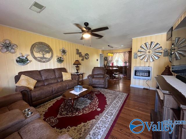 living room featuring dark hardwood / wood-style flooring, heating unit, and ceiling fan